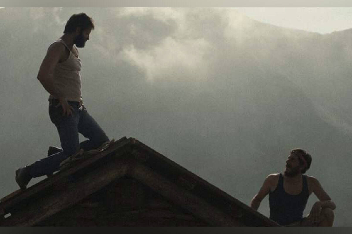 Film: The Eight Mountains graphic with two men on a mountaintop